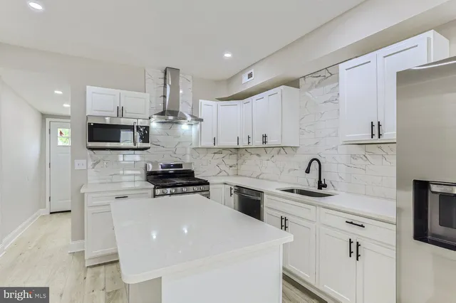a kitchen with stainless steel appliances a stove refrigerator sink and cabinets