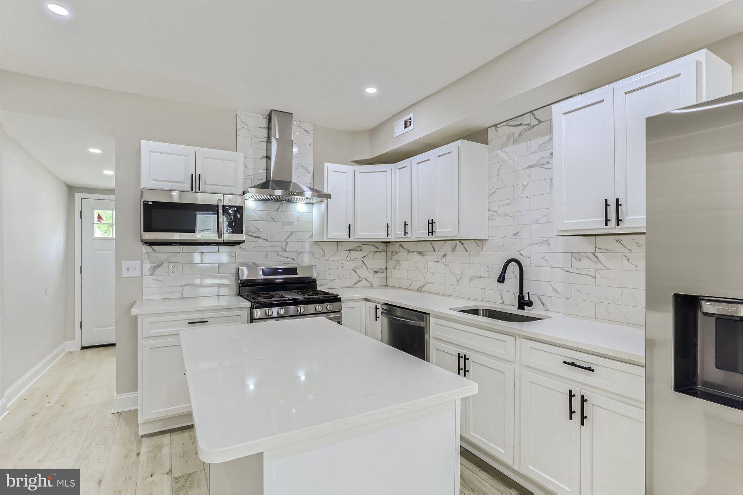 2829 Miles Avenue Baltimore, MD 21211 - Photo 7 of 25 a kitchen with stainless steel appliances a stove refrigerator sink and cabinets