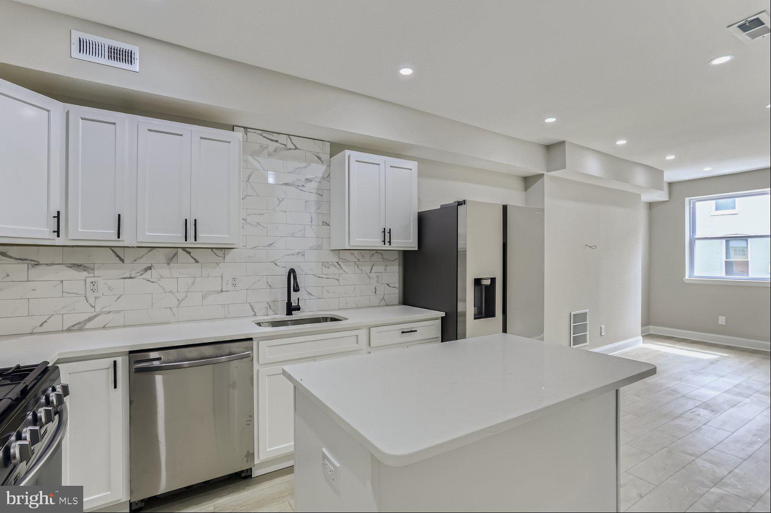 2829 Miles Avenue Baltimore, MD 21211 - Photo 8 of 25 a kitchen with stainless steel appliances a sink a stove a refrigerator and cabinets