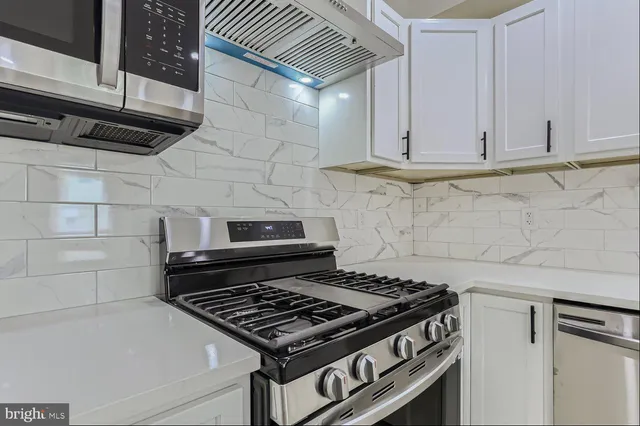 a stove top oven sitting inside of a kitchen