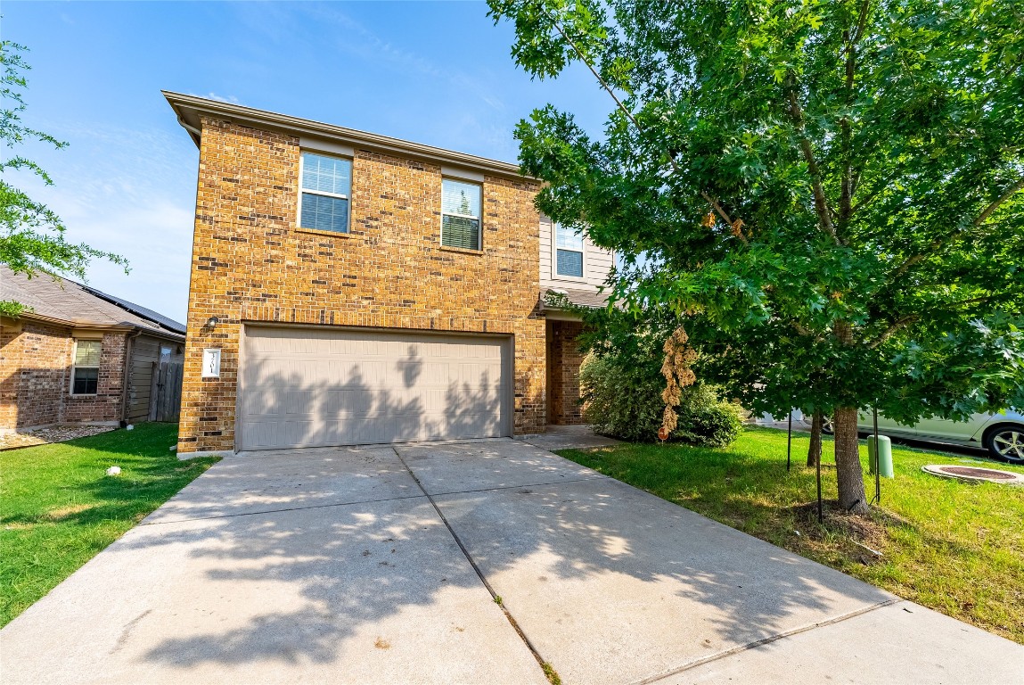 a front view of a house with a yard and a garage