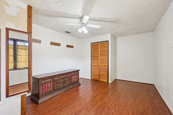 a view of a livingroom with wooden floor and a ceiling fan