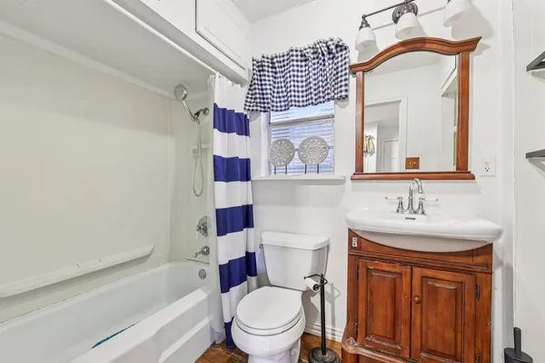 a view of an empty room with wooden floor and windows