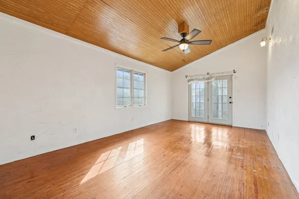 a view of a big room with wooden floor closet and windows