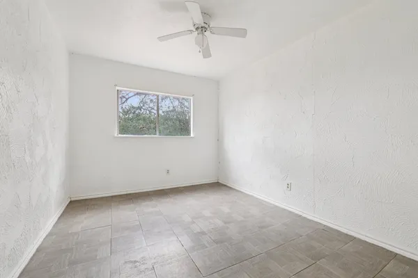 an empty room with closet and a chandelier fan
