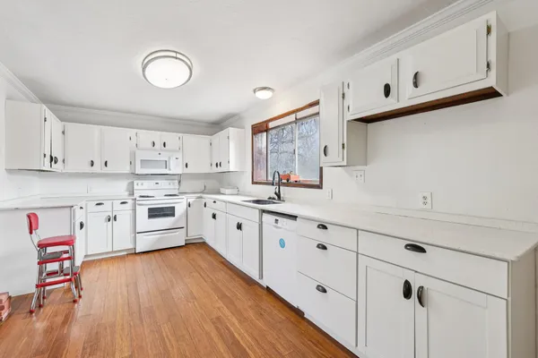 a kitchen with cabinets a sink and wooden floor