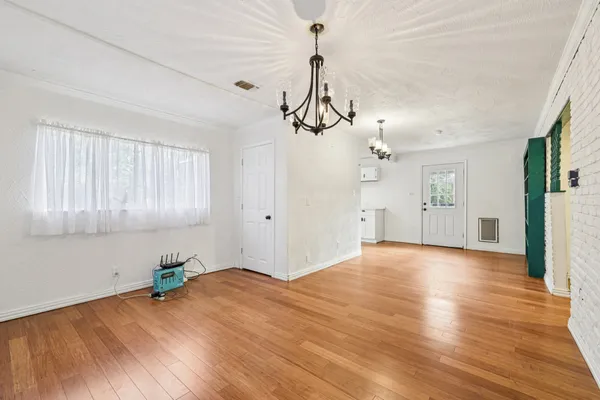 a view of empty room with wooden floor and windows