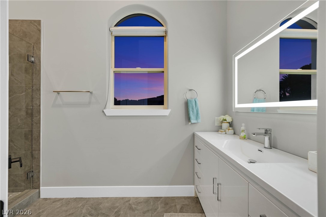 6 Rue Du Ville Henderson, NV 89011 - Photo 66 of 99 This primary bathroom features a contemporary vanity, a spacious shower, and elegant tile flooring.