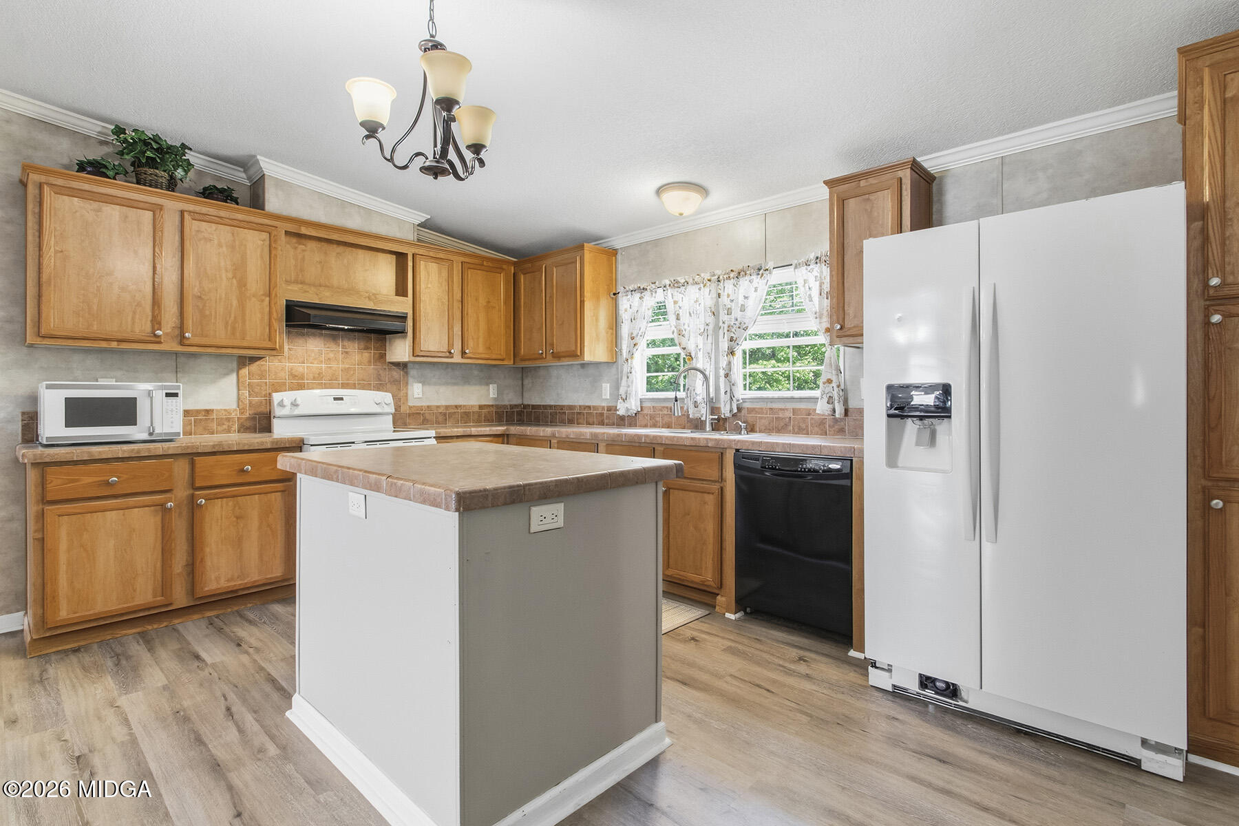 398 Jeffrey Way Forsyth, GA 31029 - Photo 15 of 34 a kitchen with a refrigerator a sink dishwasher a stove and a microwave oven with cabinets