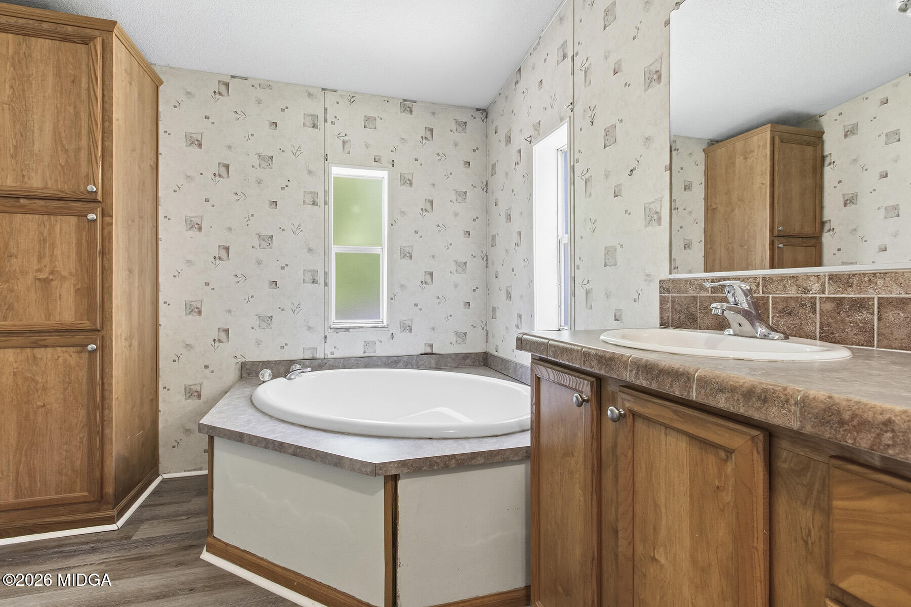 398 Jeffrey Way Forsyth, GA 31029 - Photo 28 of 34 a bathroom with a granite countertop sink a mirror a bathtub and shower