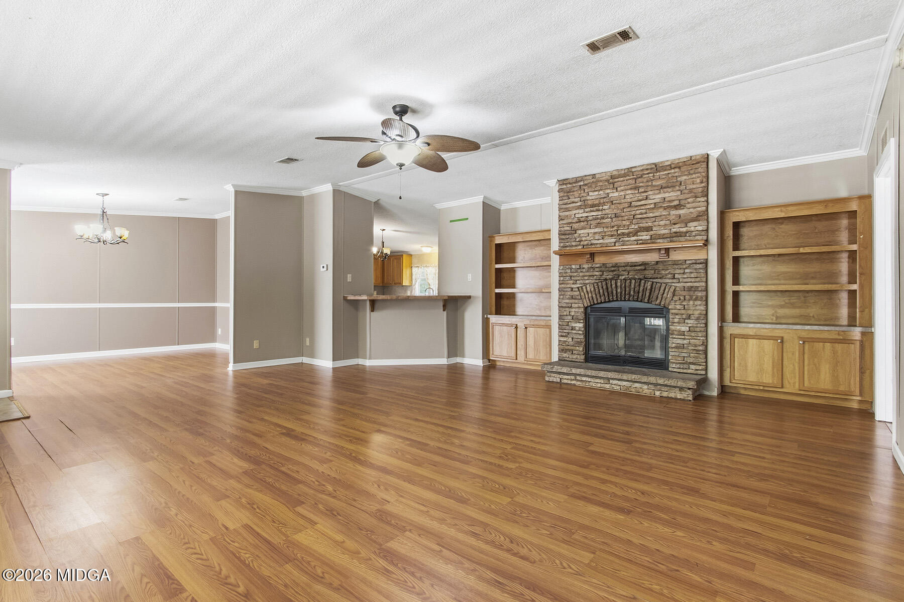 398 Jeffrey Way Forsyth, GA 31029 - Photo 7 of 34 an empty room with wooden floor fireplace cabinet and windows