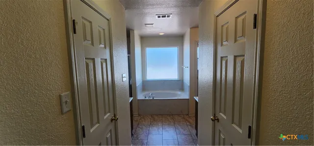 a bathroom with a tub sink and mirror