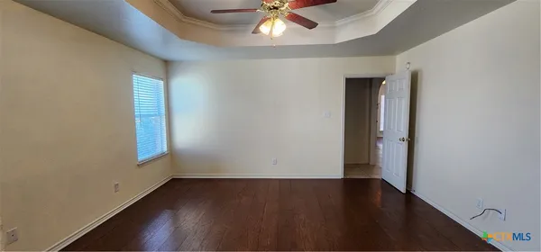 an empty room with a window and a ceiling fan