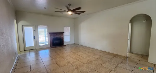 an empty room with a fireplace and windows