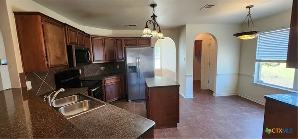 a kitchen with sink refrigerator and window