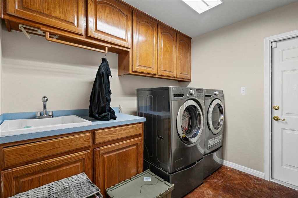 101 Valley Vista Road Wimberley, TX 78676 - Photo 19 of 23 The laundry room features a sink and dedicated folding station and plenty of cabinets to hide the mess.