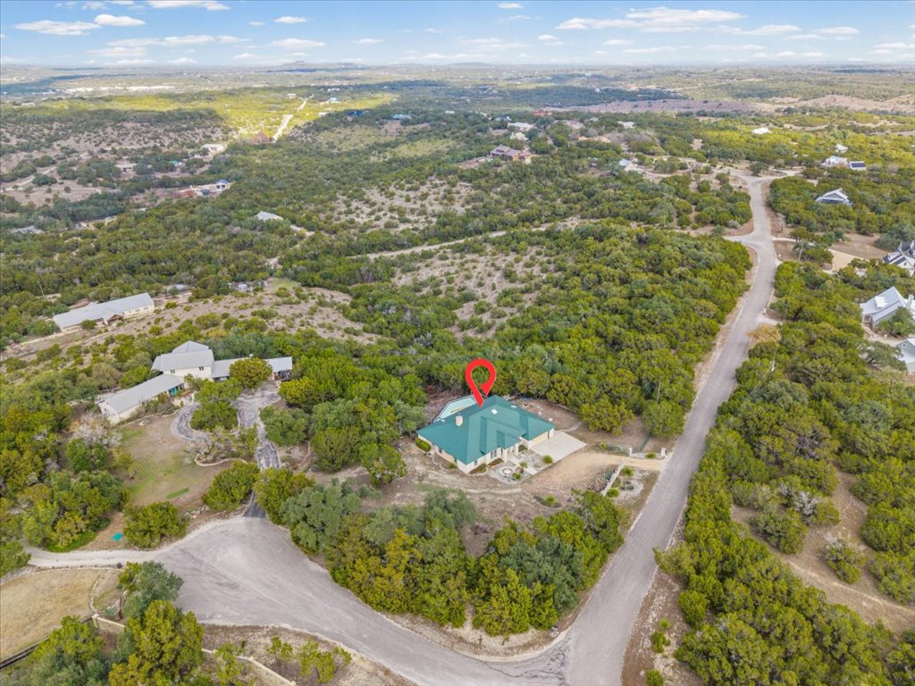 101 Valley Vista Road Wimberley, TX 78676 - Photo 22 of 23 From this angle, the bold lines of that forest green metal roof really pop against the rugged Texas landscape.
