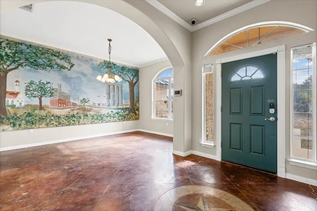 an empty room with wooden floor and a chandelier