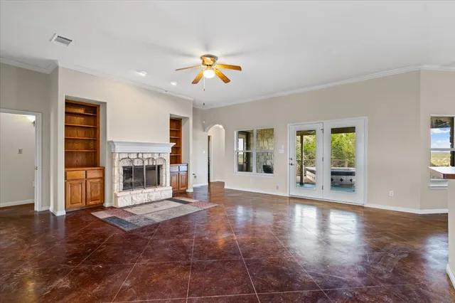 a view of an empty room with window and wooden floor