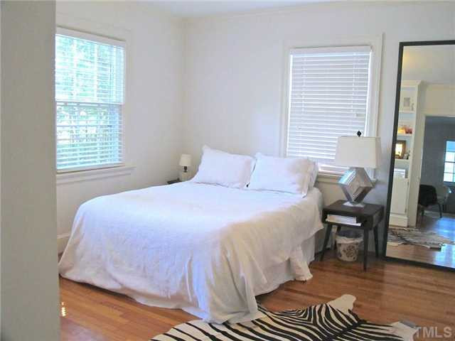 2113 Reaves Drive Raleigh, NC 27608 - Photo 11 of 18 a bedroom with a bed and wooden floor