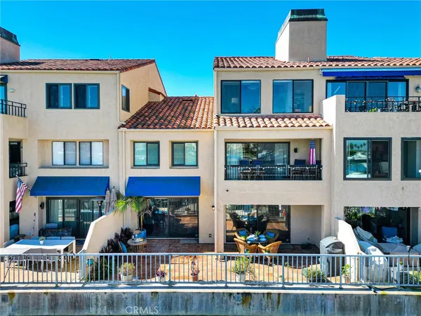 a view of a brick house with large windows and a small yard