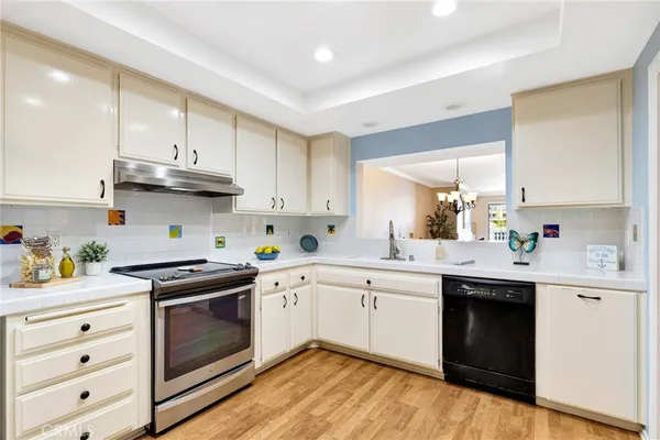 a kitchen with stainless steel appliances granite countertop a sink a stove and cabinets with wooden floor