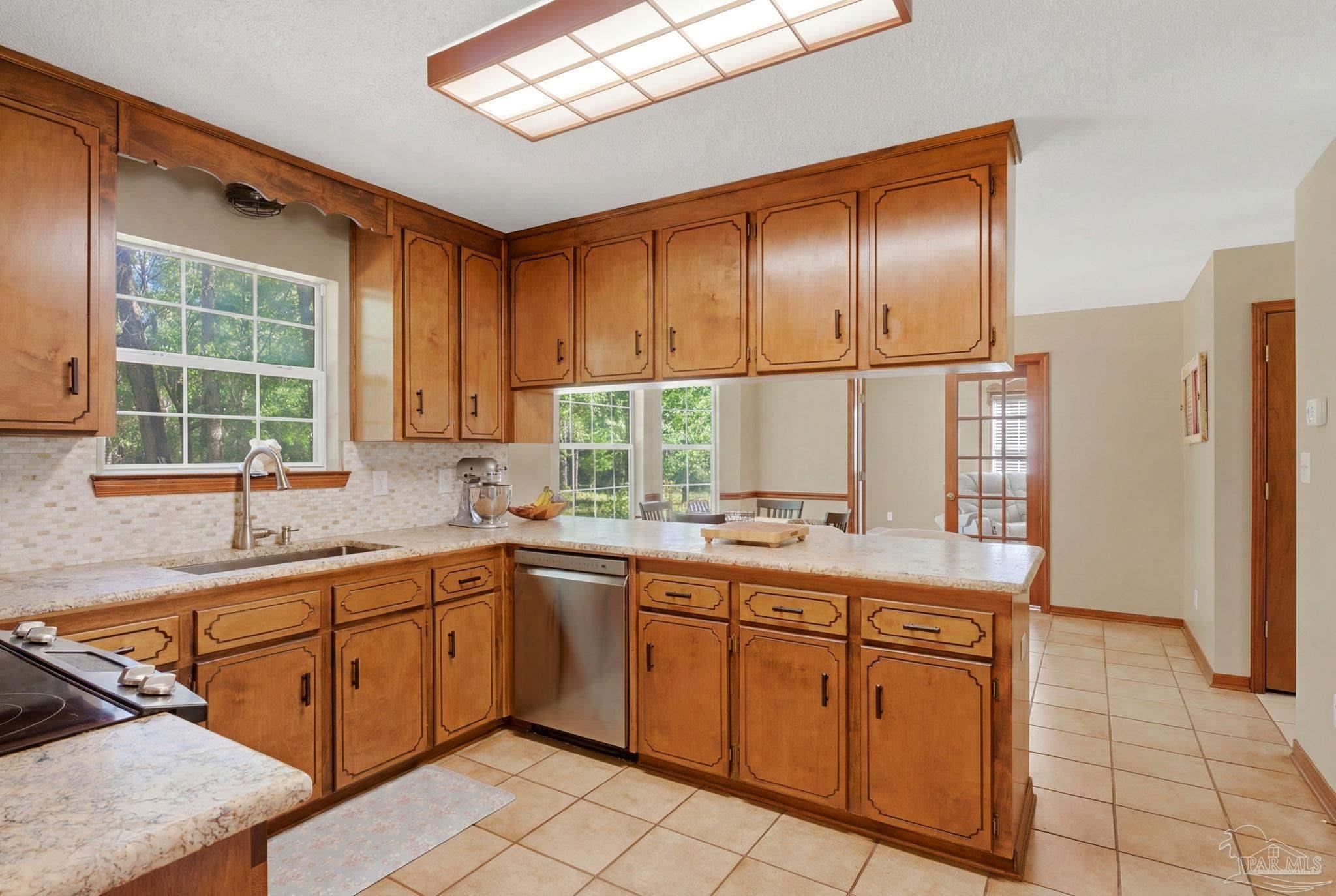 6870 Martin Road Milton, FL 32570 - Photo 13 of 48 a kitchen with a sink window and cabinets