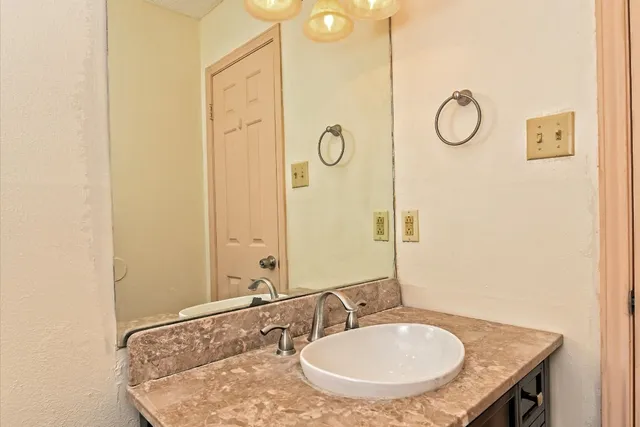 a bathroom with a granite countertop sink and a mirror