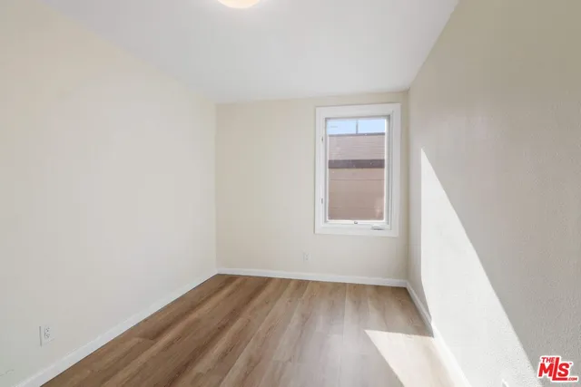 a view of a small space with wooden floor and a window