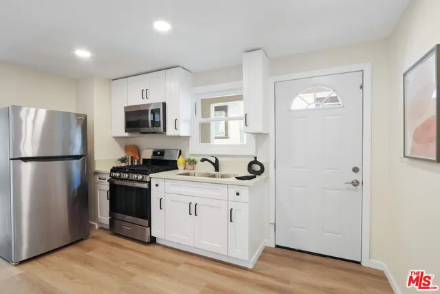 a kitchen with a refrigerator stove and sink
