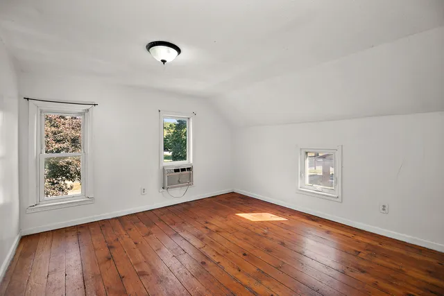 a view of empty room with wooden floor
