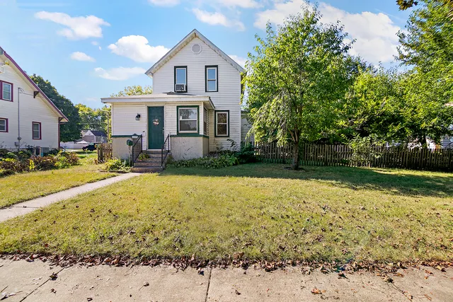 a view of a white house with a yard
