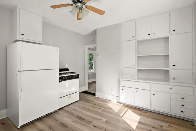 a kitchen with cabinets a refrigerator and a stove