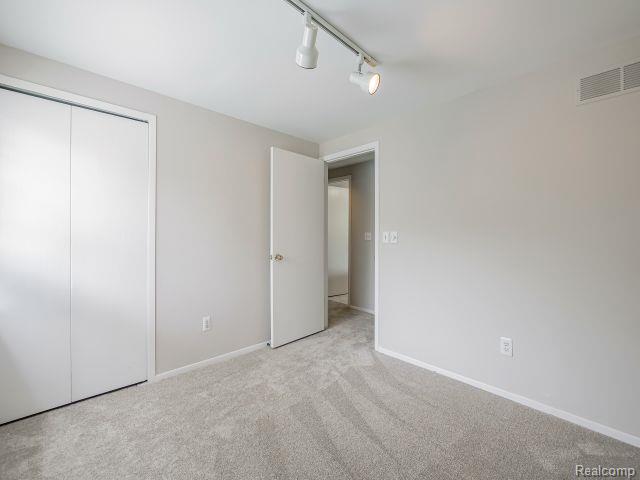 21728 Ruth Street Farmington, MI 48336 - Photo 35 of 54 Carpeted room with a double-door closet, track lighting, and neutral wall paint