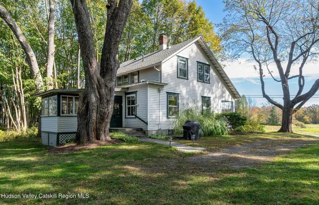 a front view of a house with a yard and tree