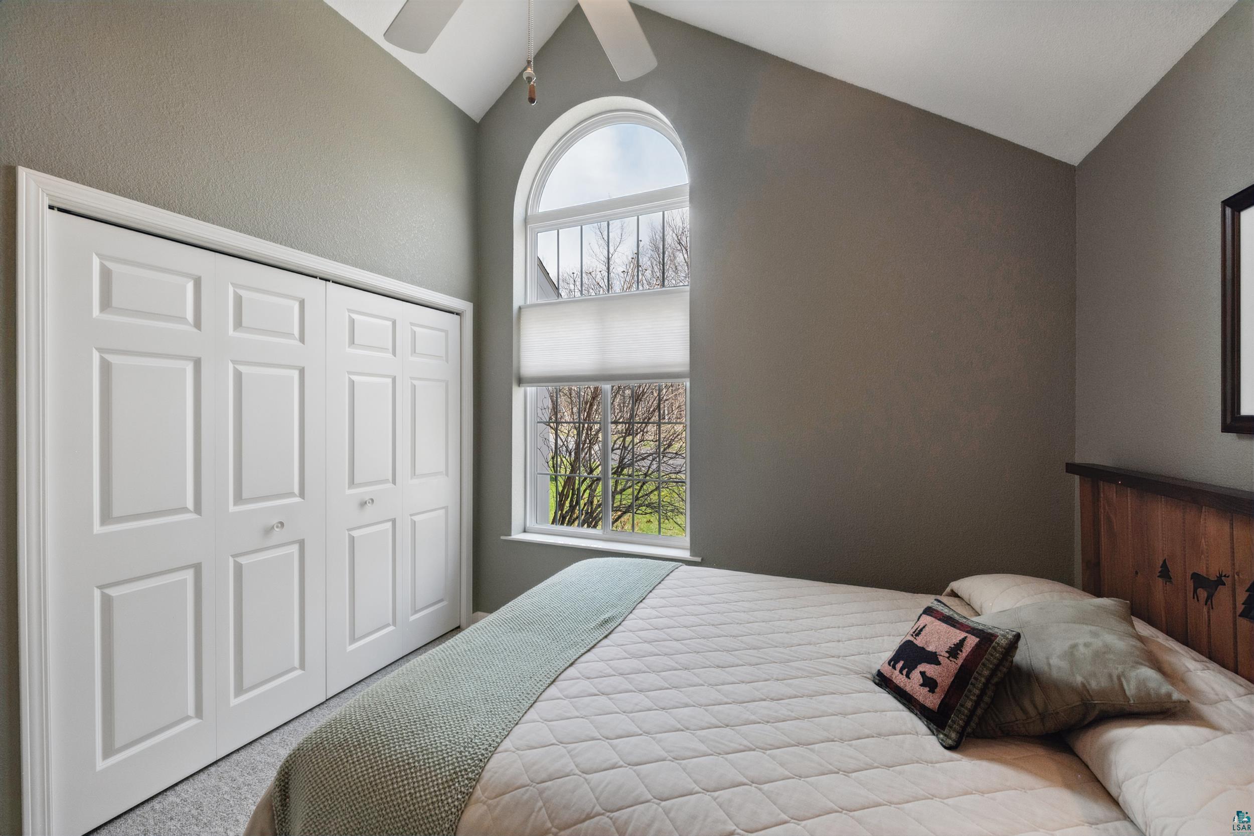 34590 Bay View Road, Unit 801 Bayfield, WI 54814 - Photo 17 of 36 Arched window with upper transom, vaulted ceiling, and ceiling fan