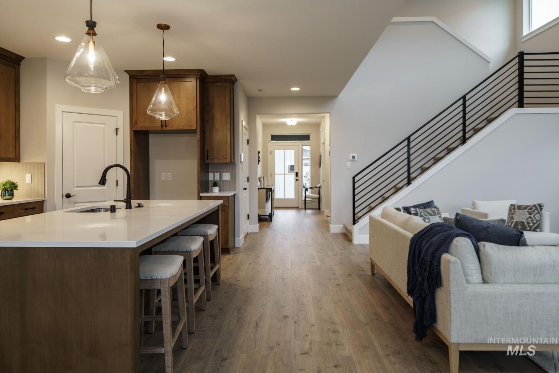 1009 West Malbar Street Meridian, ID 83646 - Photo 10 of 10 Kitchen with light wood-type flooring, light countertops, open floor plan, recessed lighting, and decorative light fixtures