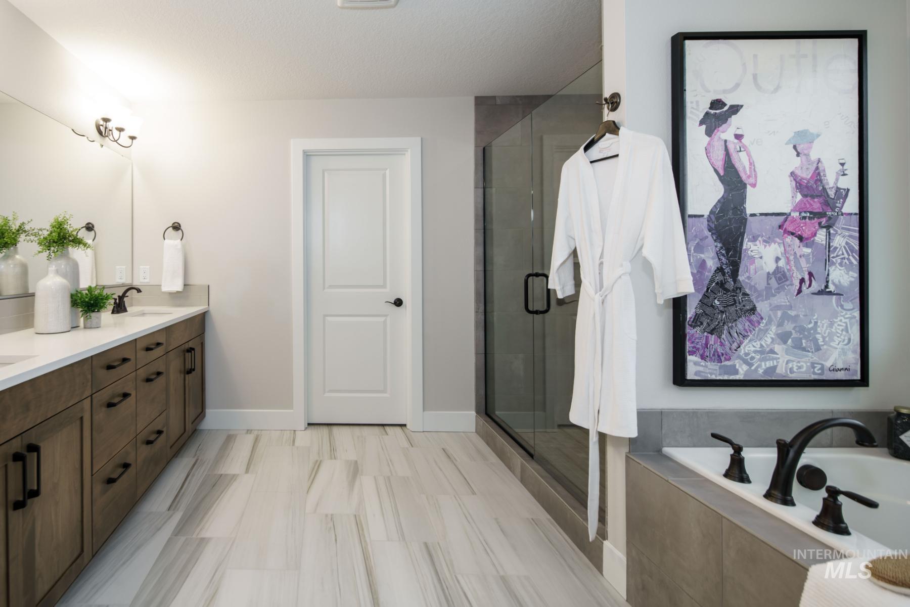 1009 West Malbar Street Meridian, ID 83646 - Photo 8 of 10 Full bathroom featuring double vanity, a bath, and a shower stall
