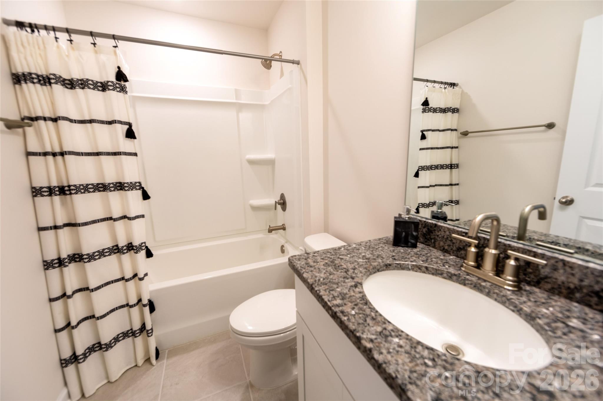 151 Aviendha Lane Troutman, NC 28166 - Photo 34 of 43 a bathroom with a granite countertop sink a toilet and shower