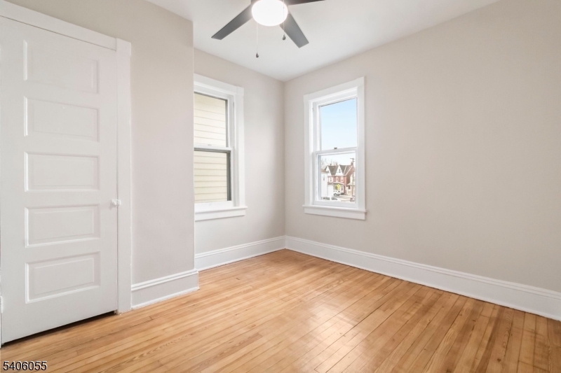 233 Irwin Street Phillipsburg, NJ 08865 - Photo 16 of 33 an empty room with wooden floor chandelier fan and windows