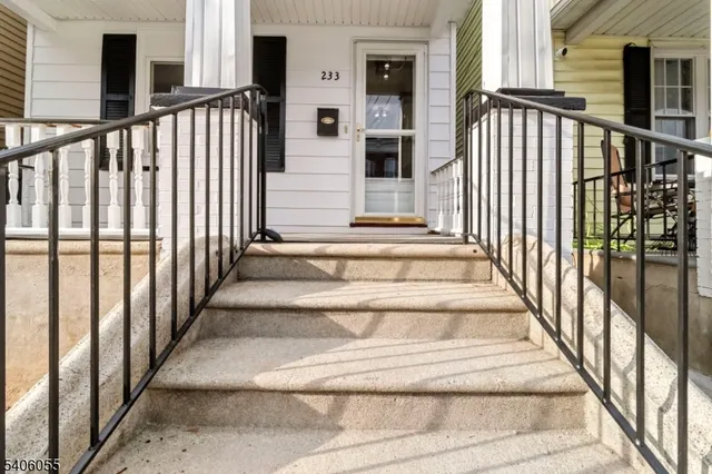 a view of staircase with lots of frames on wall and windows