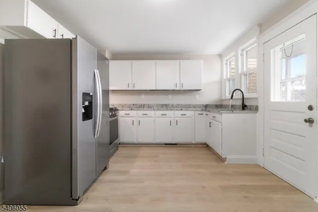 a kitchen with stainless steel appliances granite countertop a refrigerator sink and cabinets