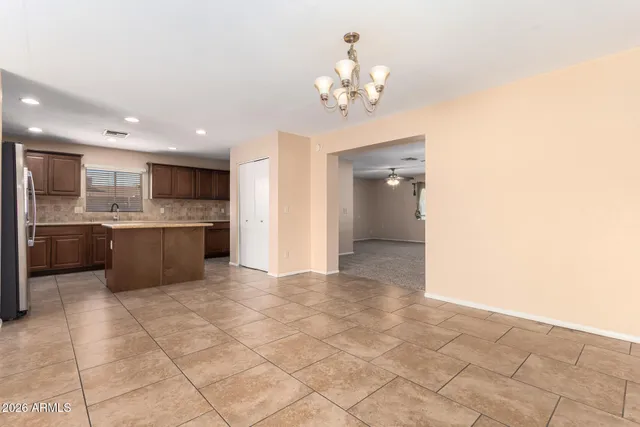 a view of kitchen with granite countertop cabinets and refrigerator