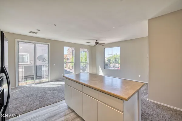 a large white kitchen with kitchen island a sink stainless steel appliances and cabinets
