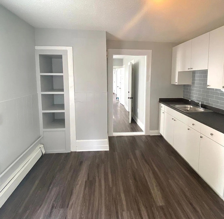 15 Shurtleff Street Chelsea, MA 02150 - Photo 4 of 9 a kitchen with wooden floors and white cabinets