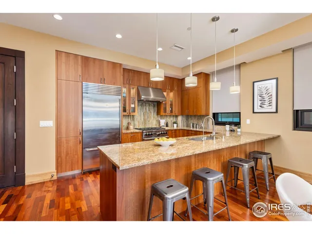 a kitchen with stainless steel appliances granite countertop a sink refrigerator and cabinets