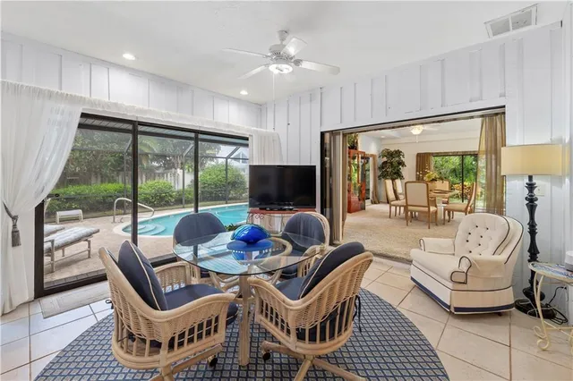 a dining room with furniture a large window and a chandelier