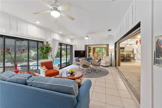 a living room with furniture a large window and chandelier