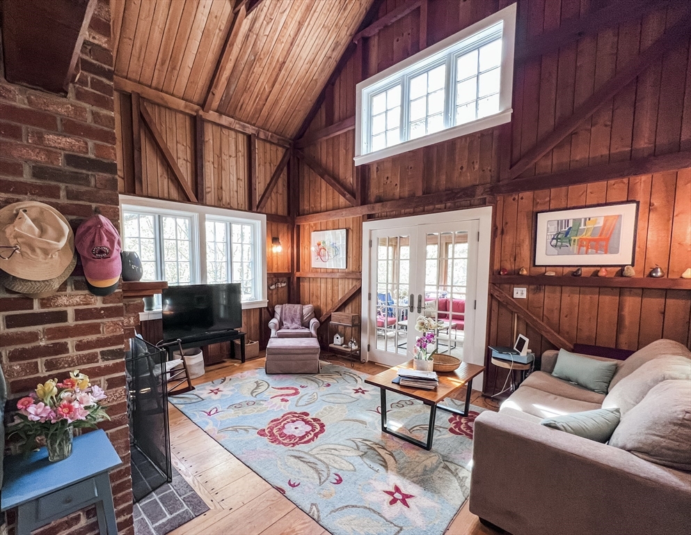 225 Lamberts Cove Road West Tisbury, MA 02568 - Photo 2 of 33 a living room with furniture a flat screen tv and a floor to ceiling window