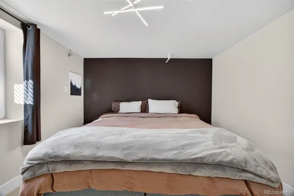 a large bed in a bedroom next to a window
